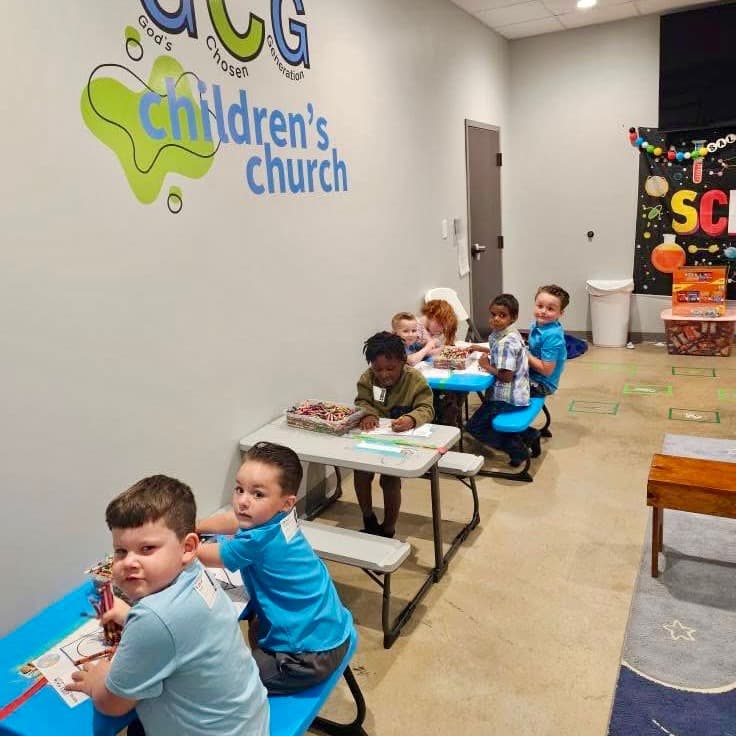 Preschoolers coloring at their tables in the GCG children's church room